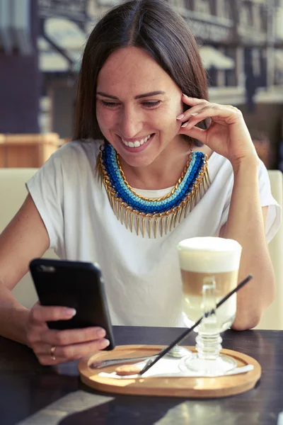 Женщина в кафе со смартфоном — стоковое фото