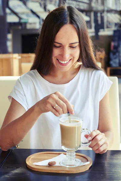 Vrouw kijken naar haar cappuccino — Stockfoto