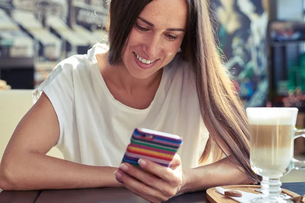 Frau blickt auf ihr Smartphone — Stockfoto