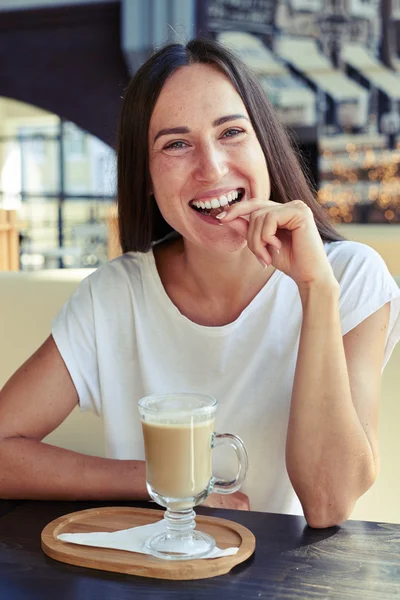 Frau mit Keksen und Cappuccino — Stockfoto