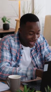 Bir zaferi ya da bilgisayarında iyi haberi kutlayan mest bir adamın dikey videosu. Evden çalışırken şaşkınlık ve neşe gösteriyor..