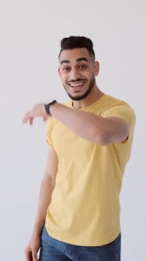 Dost canlısı bir adam elini sallıyor ve kameraya doğru işaret ediyor. Dikey video beyaza izole edildi.