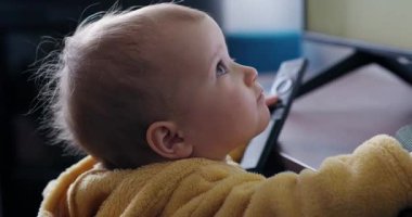 Gülümseyen bir anne, bebeğinin şehir dışındaki bir parkta sallanan bir oyuncağa binmesine yardım eder. Güneşli bir günde birlikte gülüp eğleniyorlar..