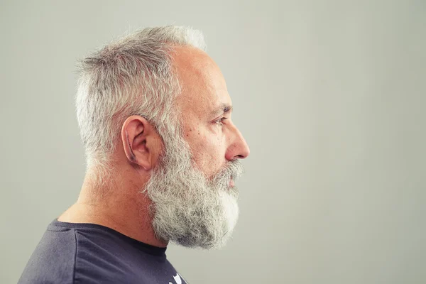 Senior vousatý muž nad světle šedé pozadí — Stock fotografie