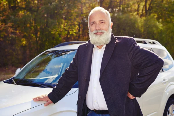 Smiley senior homme près de sa voiture blanche à l'extérieur — Photo