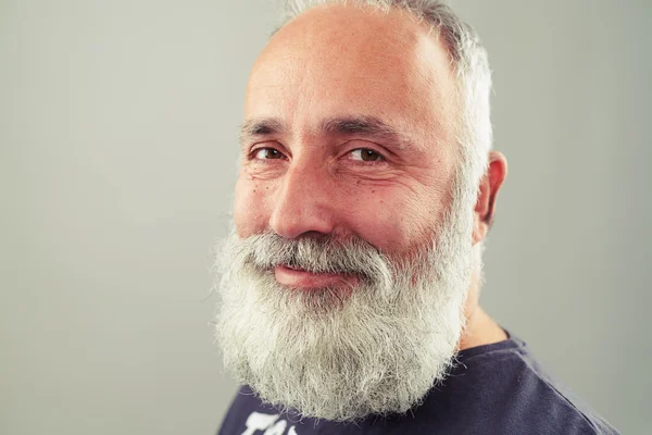 Sorridente barbudo sênior homem sobre luz cinza fundo — Fotografia de Stock