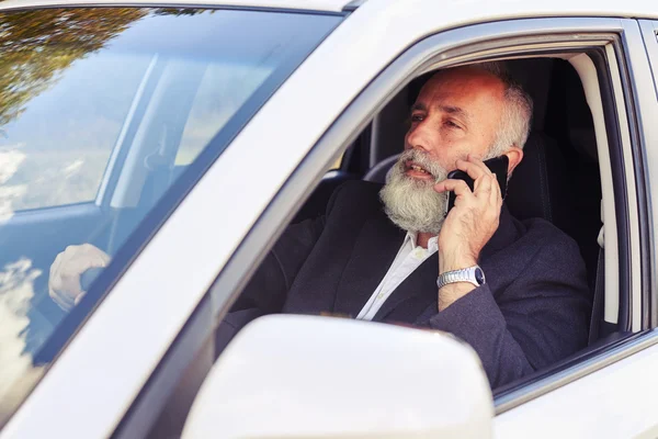 Hombre conduciendo su coche y hablando por teléfono — Foto de Stock