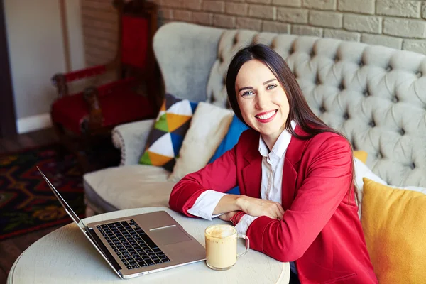 Ung kvinna med laptop och fika i café — Stockfoto