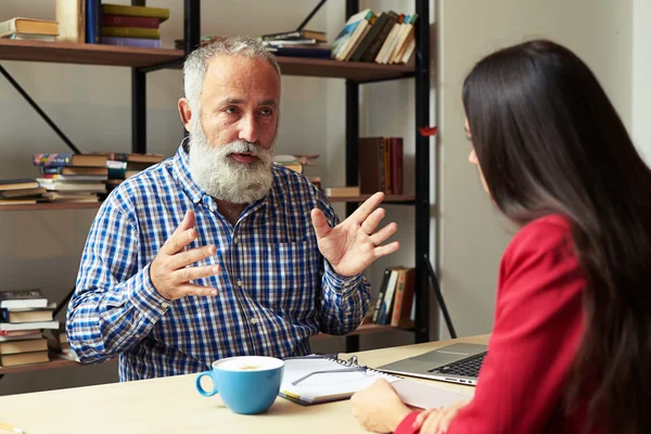 Jefe explicando algo a un joven trabajador — Foto de Stock