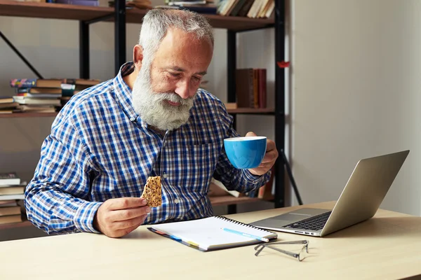 一杯のコーヒーとクッキーを保持している実業家 — ストック写真