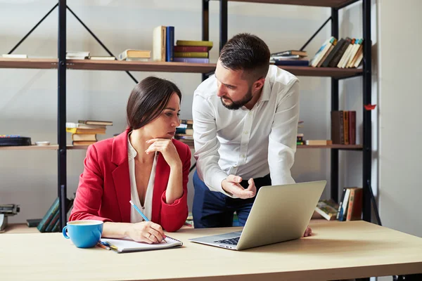 Businessman explaining something to woman and looking at her — Stock Photo, Image