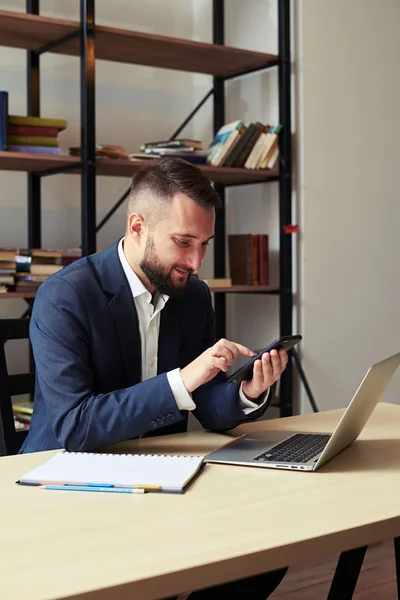 Бізнесмен використовує смартфон на своєму робочому місці — стокове фото