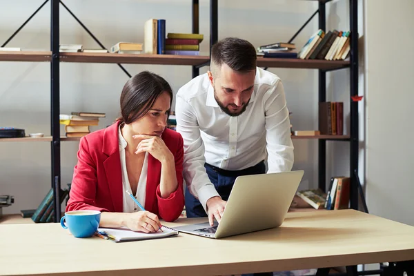 Man typing on keyboard, woman writing — Stock Photo, Image