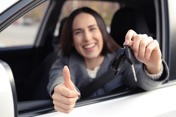 Woman holding car key and showing thumbs up — Stock Photo, Image