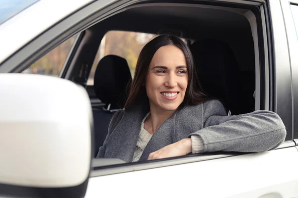 Sorridente jovem mulher no carro branco — Fotografia de Stock