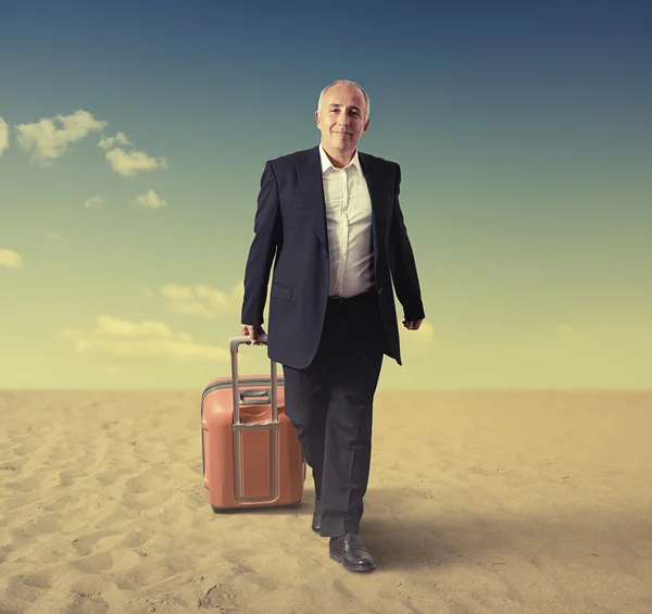 Homme âgé marchant avec valise dans un désert — Photo