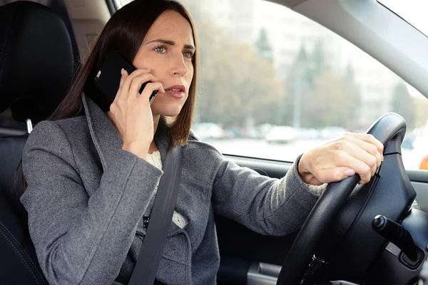Frau fährt Auto und telefoniert — Stockfoto