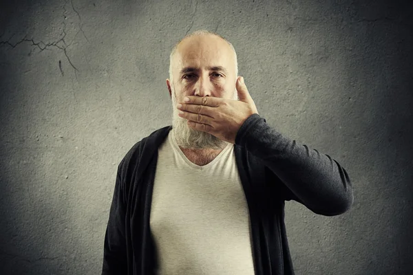 Skäggig äldre man som täcker munnen — Stockfoto