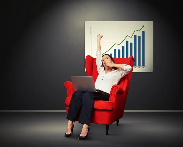 Yawning businesswoman against placard with positive graph — Stock Photo, Image