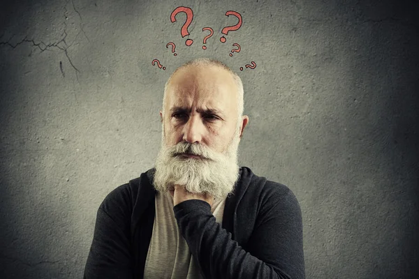 Senior man with red question marks above the head — Stock Photo, Image