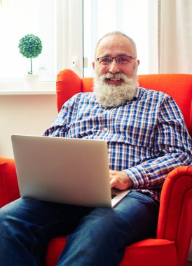 sakallı adam dizüstü bilgisayar ile sandalyeye dinlenme