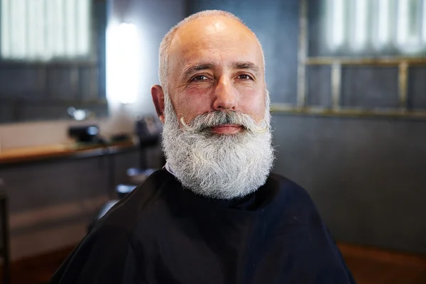 Veselý vousatý starší muž v holičství — Stock fotografie