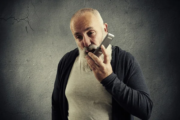 Äldre man håller hans mobiltelefon och skriker — Stockfoto