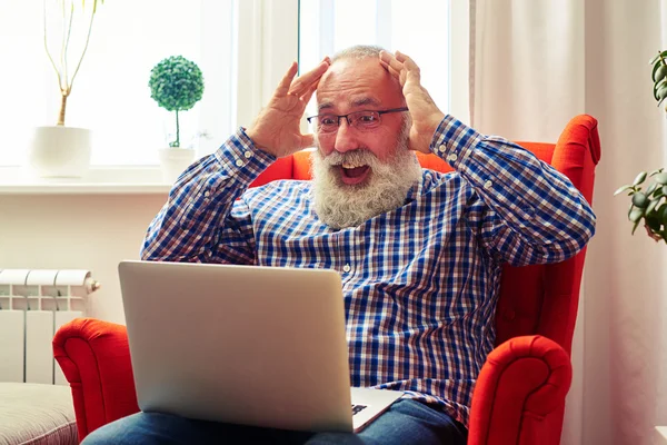 Förvånad senior man med laptop — Stockfoto