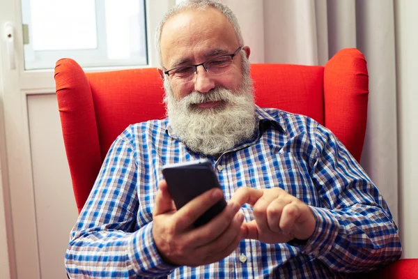 Smiley senior man met smartphone — Stockfoto
