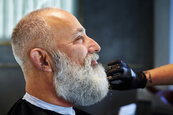 Smiley uomo dai capelli grigi nel negozio di barbiere — Foto Stock