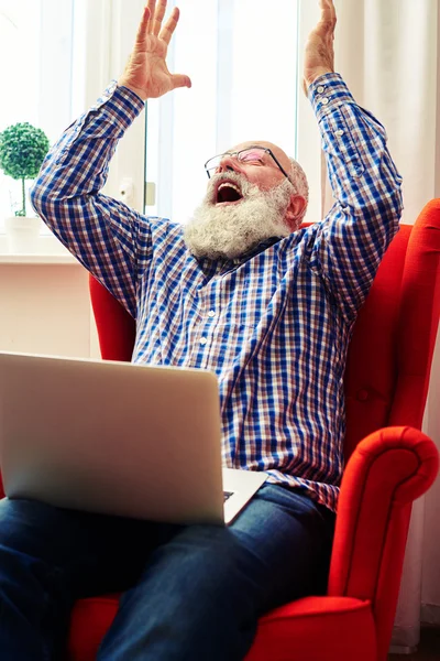 Senior lycklig med laptop höjer händerna upp — Stockfoto