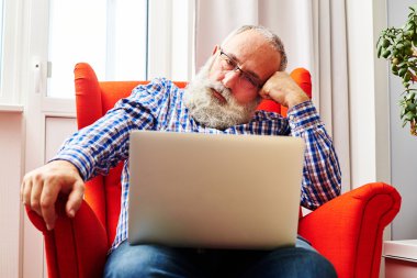 adam kırmızı sandalyede oturan ve laptop arıyorum