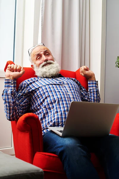 Man met laptop op de stoel thuis — Stockfoto