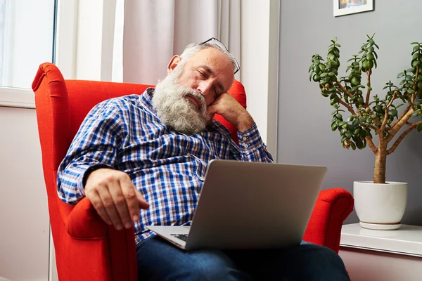 Trött senior man sova med laptop — Stockfoto