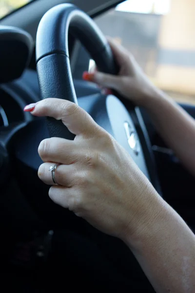 Female hands controlling steering wheel — Stock Photo, Image