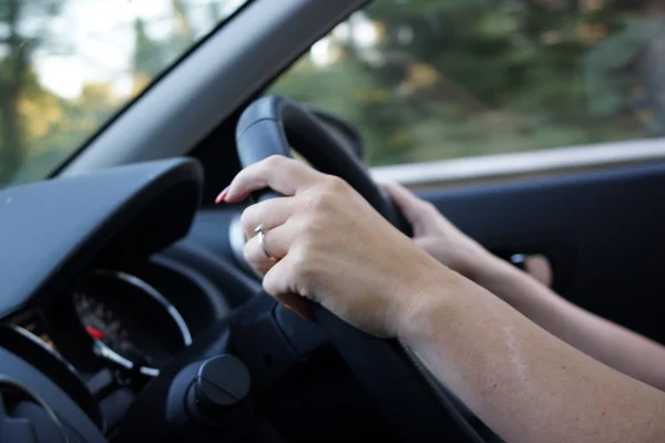 Kvinnliga händer kontroll ratt — Stockfoto