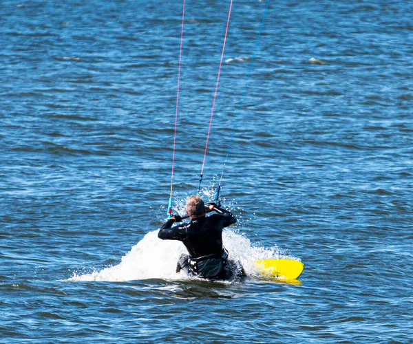 Ein Mann Fängt Gerade Den Wind Mit Seinem Kitesurfbrett Beim — Stockfoto