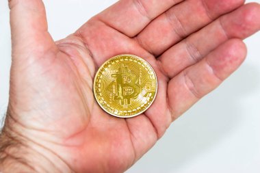 Avucundaki beyaz arka planı olan altın bitcoin..