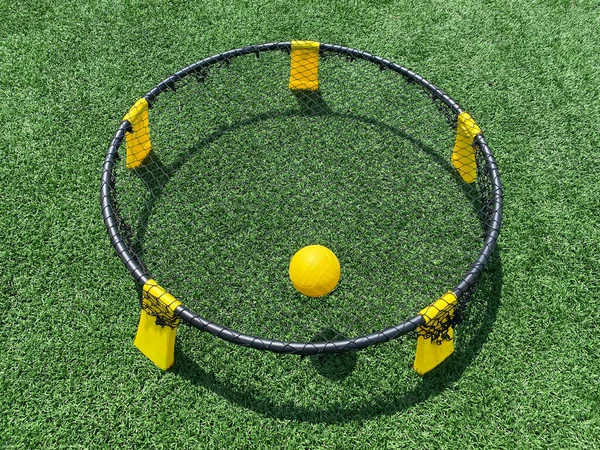 黄色と黒のスパイクボールゲームの閉鎖は ネット上の黄色のボールと緑の芝生のフィールドに設定されます — ストック写真