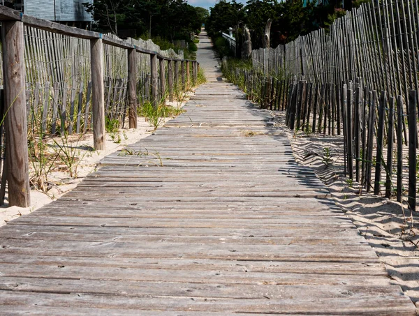 A wood path on Fire Island leading from the beach between the dunes to get to vactions homes and businesses.