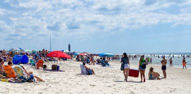 Fire Island, New York, ABD - 23 Mayıs 2021: Alev Adası 'ndaki Rober Moses Fiel 2 plajına kalabalığı getiren sıcak hava dalgası sırasında plajda soğutucu taşıyan iki kız.