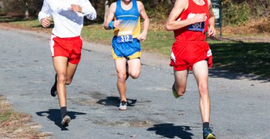 Van Cortlandt parkındaki çakıllı yolda koşan üç liseli çocuk..