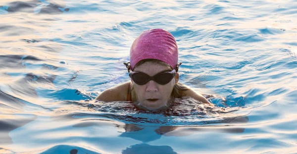 분홍색 수영복 구글링을 수영장에서 스트로크를 수영하는 사람들의 머리가 보이는 — 스톡 사진
