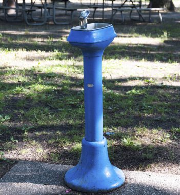 Belmont Gölü Parkı 'ndaki eski mavi bir su çeşmesinin dikey görüntüsü.