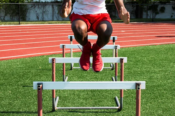 Vista Frontal Chico Secundaria Afroamericano Saltando Sobre Obstáculos Pista Campo —  Fotos de Stock
