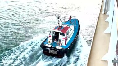 Açıklama: Bordeaux, Fransa 11 Ağustos 2025: Bir yolcuyu almak için hareket halindeki bir yolcu gemisinin hızına uymaya çalışan pilot gemisi.