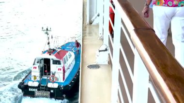 Açıklama: Bordeau, Fransa 11 Ağustos 2025: Her iki tekne de denizde hareket ederken bir yolcu gemisinden işçi alan bir pilot tekne.