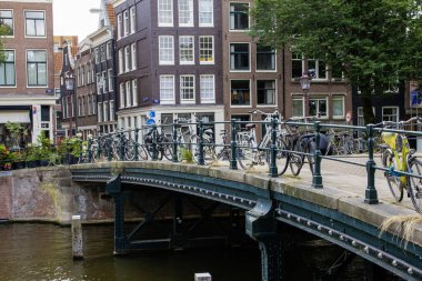 Bisikletler Amsterdsm 'deki bir kanala bakan bir köprüye park edilmiş..