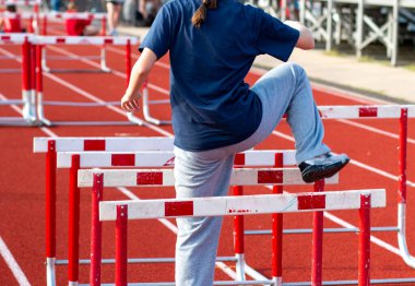 Pistteki antrenman sırasında genç bir insan engeli aşar.
