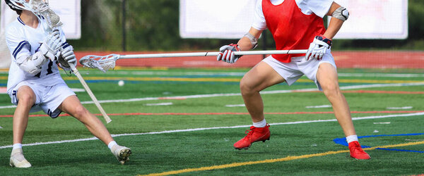 Team members engage in an intense lacrosse practice session on the field.